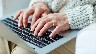Hands typing on a laptop