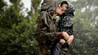 Mom and little boy playing in the rain.