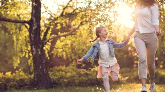 Mother and daughter skipping.