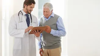 A man reviews his test results with his doctor at his annual appointment.
