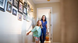 AdventHealth Nurse being led by child down hallway of their home