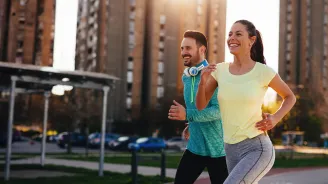 Couple running outside in the city during sunset.