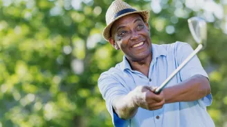Mature golfer teeing off