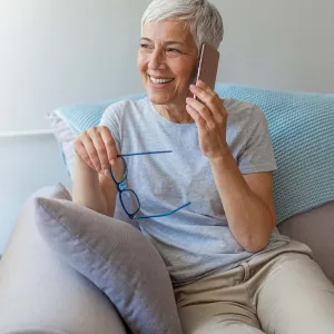 A woman on her cell phone at home on her couch. 