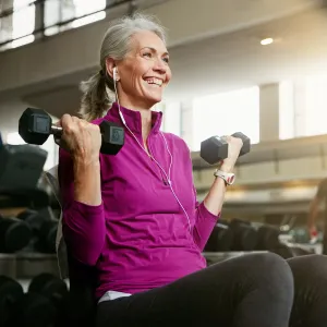 A Senior Woman Works Out at the Gym with a Smile on Her Face