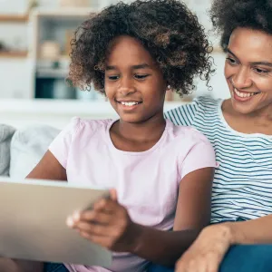 A Mother and Daughter Enjoy Surfing the Internet Together While Sitting in Their Home.