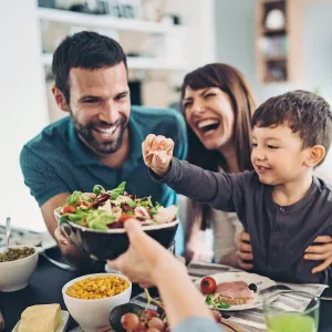 A Family Gathers Around The Kitchen Table To Enjoy Some Healthy Foods.