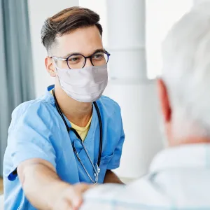 A Doctor Comforts an Elderly Patient in an Exam Room.