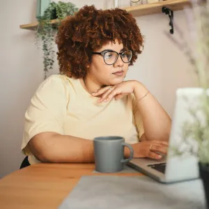 A Woman Explores Her Options on Her Laptop at the Kitchen Table