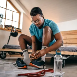 A young man tying his shoes