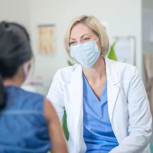 A Doctor Speaks to a Patient in the Practice Lobby