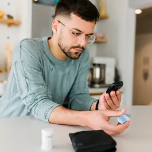 A Man Checks His Glucose Levels in His Kitchen