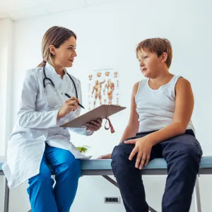 A Doctor Speaks to Her Adolescent Patient in an Exam Room