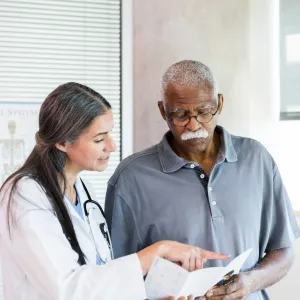 A Doctor Goes Over a Brochure with Her Senior Patient 