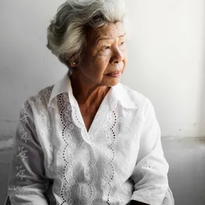 A Senior Woman Stares Out of a Window