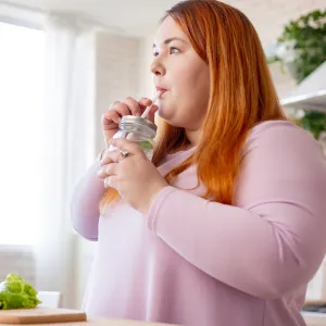 A Woman Drinks Infused Water In Her Kitchen
