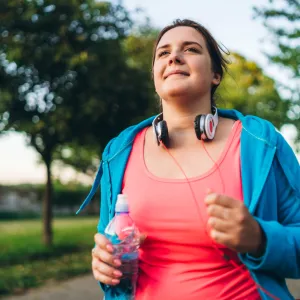 A Woman Jogging in a Park Carrying a Water Bottle