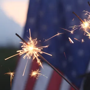 3 Sparklers Burn in Front of The American Flag