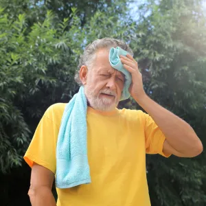 A Man Wipes the Sweat From His Forehead on a Hot Summer Day