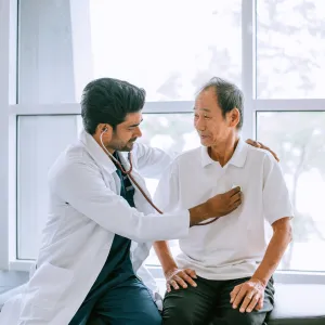 A Physician Listens to His Patients Heart with a Stethoscope