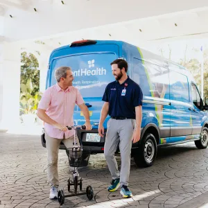 A Patient on a Scooter Smiles with an AdventHealth Employee at a Walt Disney World Resort Hotel