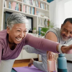 Senior Woman and Man doing pilates together at home.