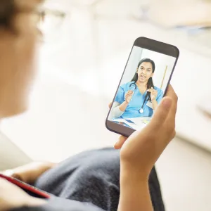 Woman on a Smart Phone having a Virtual Visit with a medical professional.