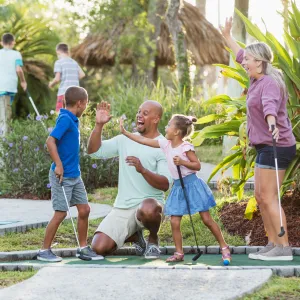 A Family Congratulates Their Son For Winning at Putt Putt Golf.