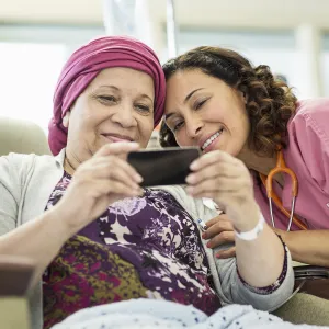 A young nurse and her female cancer patient taking a sweet selfie.