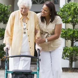 Woman in her driveway using a walker
