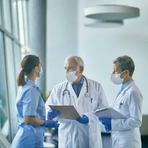 A nurse having a conversation with two doctors