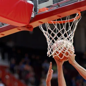 A basketball player dunking a ball.