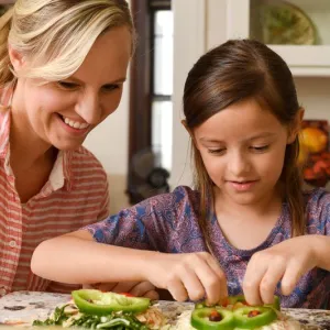 A mom and daughter cook togethter