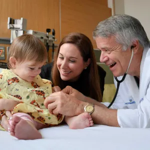 Doctor Keating using a stethoscope on his child patient