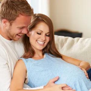 A couple admiring the belly of their baby