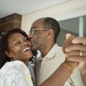 African American senior couple dancing on the balcony