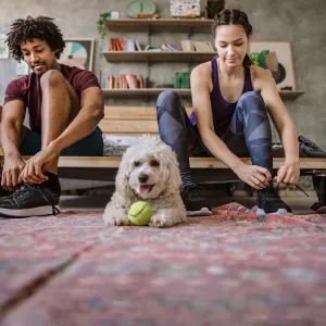 A couple lacing up their shoes for a workout together. 