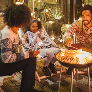 A family roasting marshmallows outside.