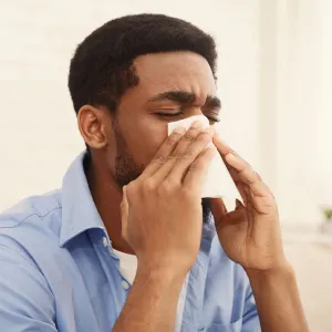 A man blowing his nose.