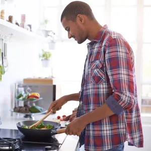 A man cooks a vegetable-based meal.