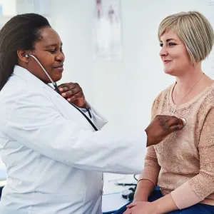A patient having her heart listened to.