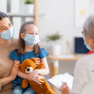 A mother and daughter talking face-to-face with a doctor