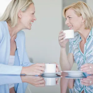 Two women chatting and drinking tea together.