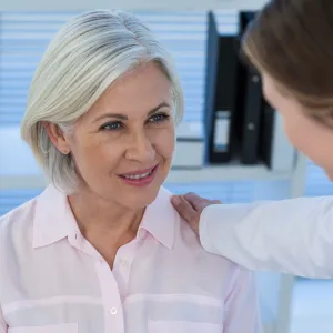 A woman talks with her doctor before an imaging test.