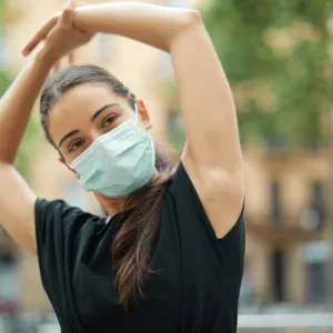 A woman stretching outside after a workout.