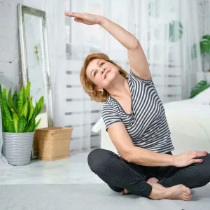 A woman stretching in her bedroom.