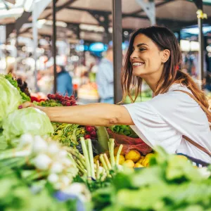 Young woman explores the farmers market for the best produce