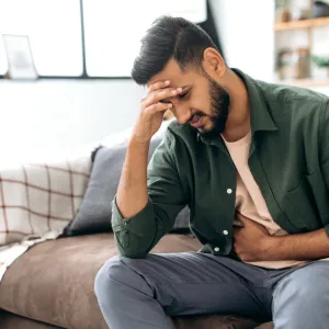 A sick man holding his forehead in his hand