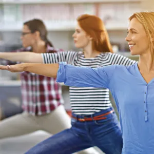 Three woman perform exercises.