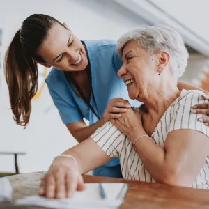 Nurse smiling with senior woman patient.